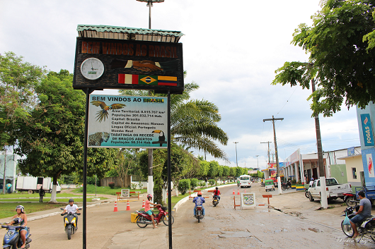 Fronteira entre dois países em uma avenida com alguns motociclistas. Uma placa dando boas-vindas está no centro da passagem (Foto: Pasión Viajes)