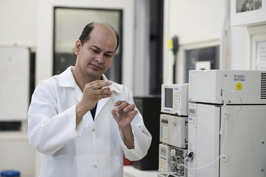 Professor Eduardo Henrique com seringa de isoniazida na mão, em laboratório (Foto: Jr. Panela/UFC)