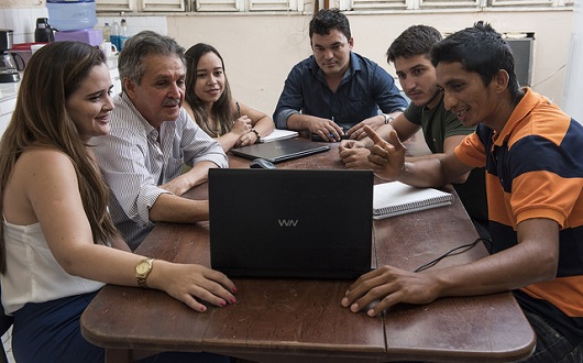 Grupo reunido na mesa, conversando e analisando a tela do computador (Foto: Jr. Panela/UFC)