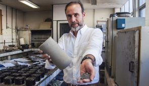 Prof. Jorge Soares mostra cinzas das termelétricas em uma mão e o bloco utilizado na construção na outra (Foto: Ribamar Neto/UFC)