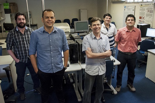 Cinco pesquisadores posando para a foto em uma sala com vários computadores (Foto: Viktor Braga/UFC)