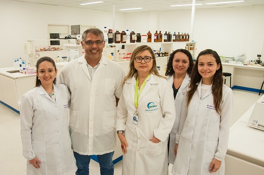 Grupo de pesquisadores (quatro mulheres e um homem) em ambiente de laboratório, posando para a foto (Foto: Ribamar Neto/UFC)