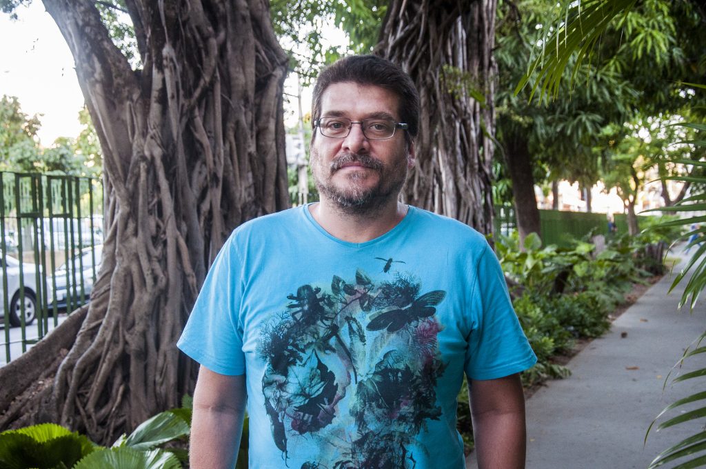 Professor Leonardo Sá, em foto de busto e rosto, em um jardim localizado na área 3 do Centro de Humanidades da UFC (Foto: Ribamar Neto/UFC)